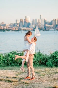Couple celebrating on the Seattle waterfront with the city skyline in the background