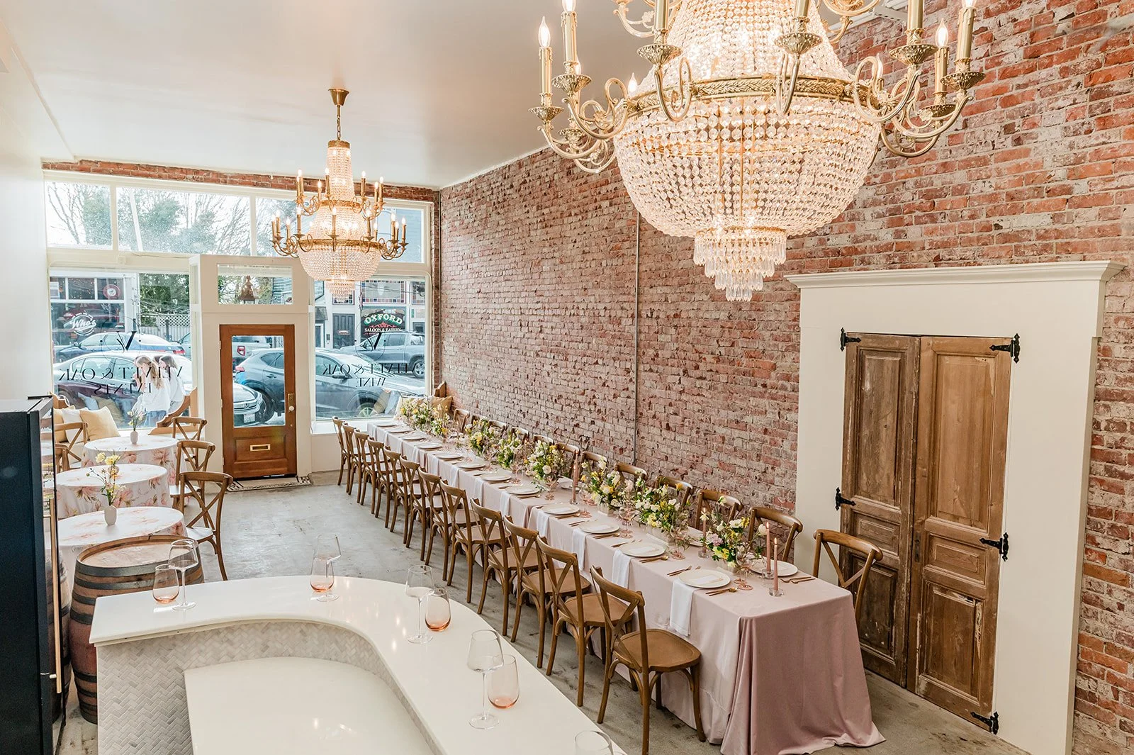 The Velvet & Oak event space — European chandeliers, original 1901 brick, spring tablescape set for a celebration