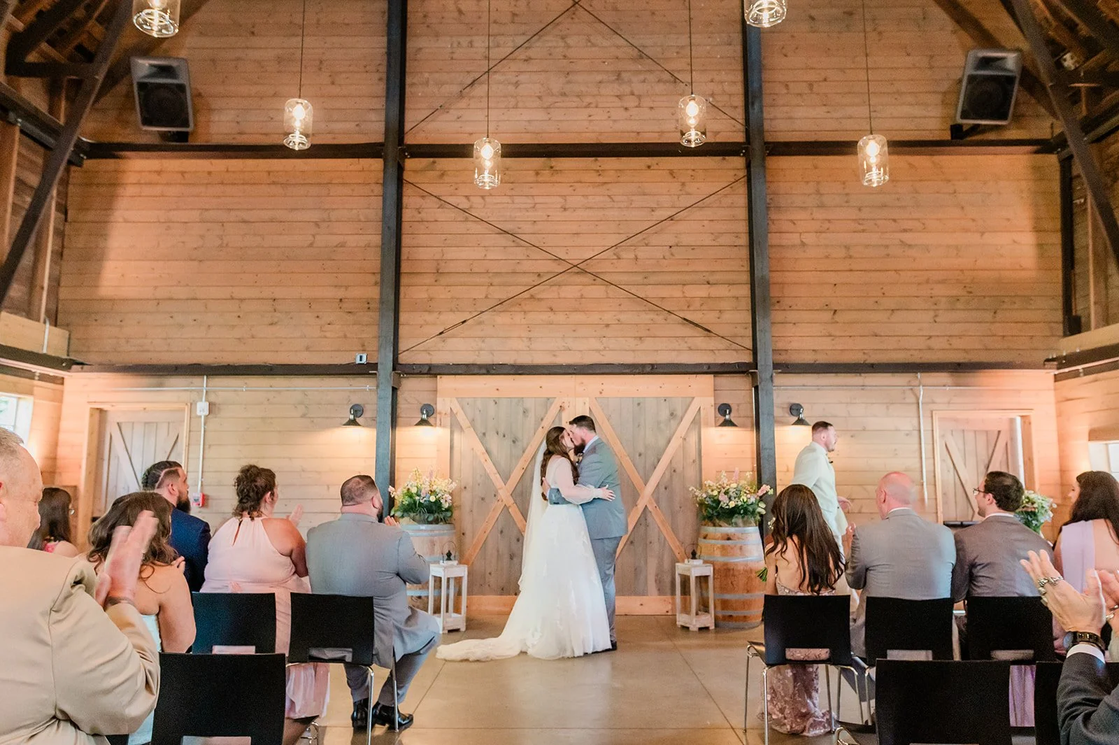 Meghan and Beau sharing their first kiss in front of 60 guests inside the historic barn