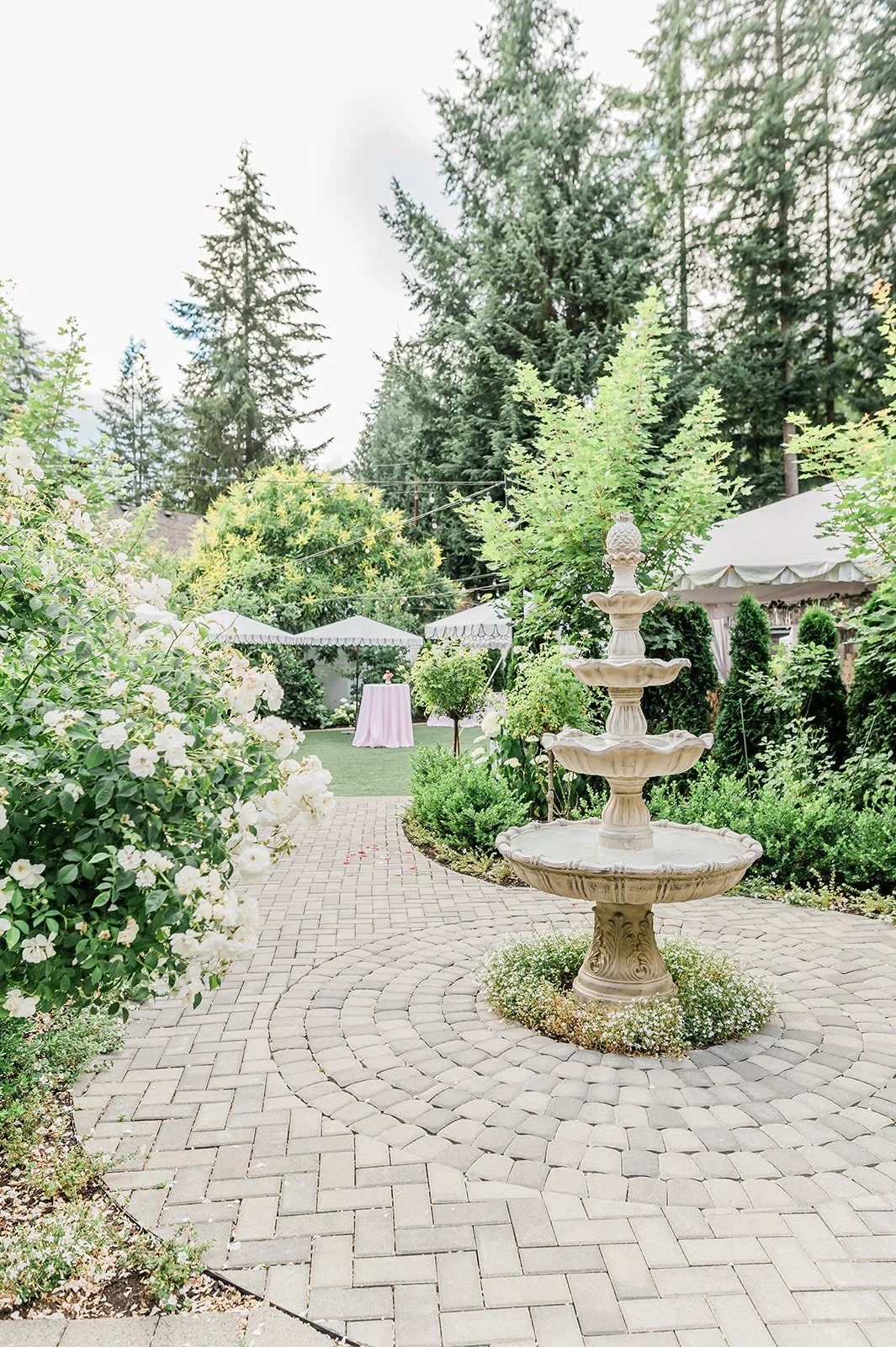 Stone tiered fountain surrounded by white florals at Jackson Manor wedding venue in Arlington, WA