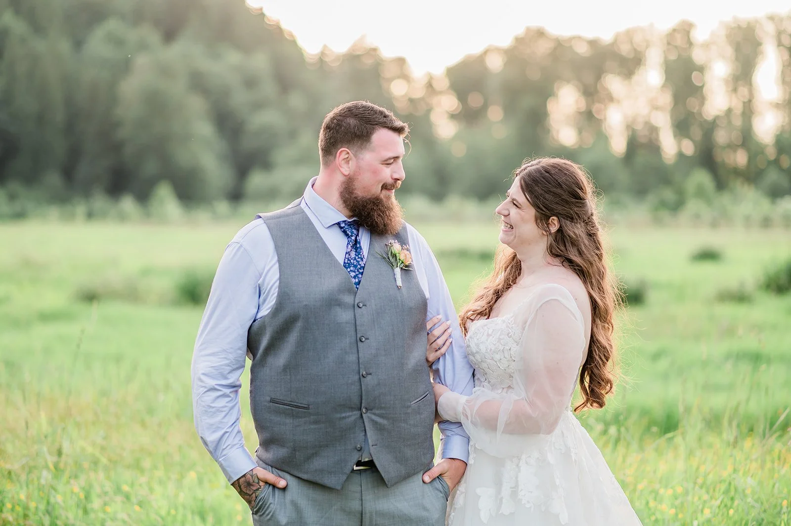 Bride and groom laughing together in an open field at Marionfield Farm in Arlington