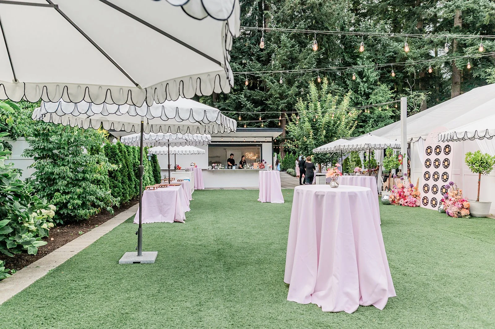 Cocktail hour setup with scalloped umbrellas and a built-in bar on the Jackson Manor lawn