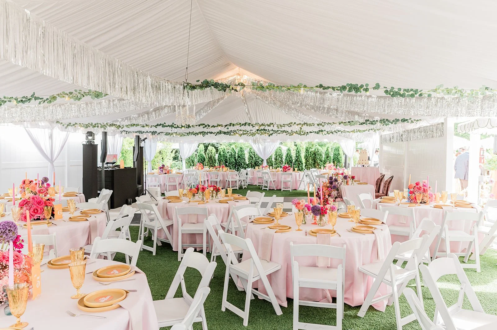 Reception tent at Jackson Manor decorated with hanging greenery garland and round tables for a rainy-day wedding backup