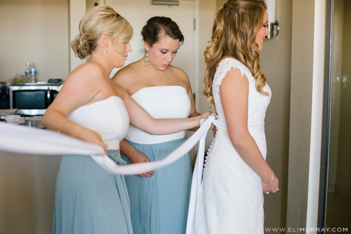 bride putting on wedding dress