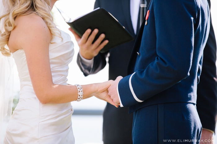 bride and groom hold hands in ceremony