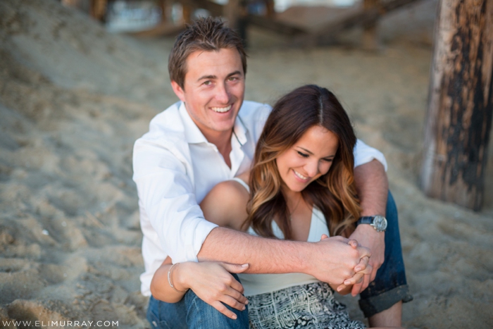 Couple sitting under newport beach pier