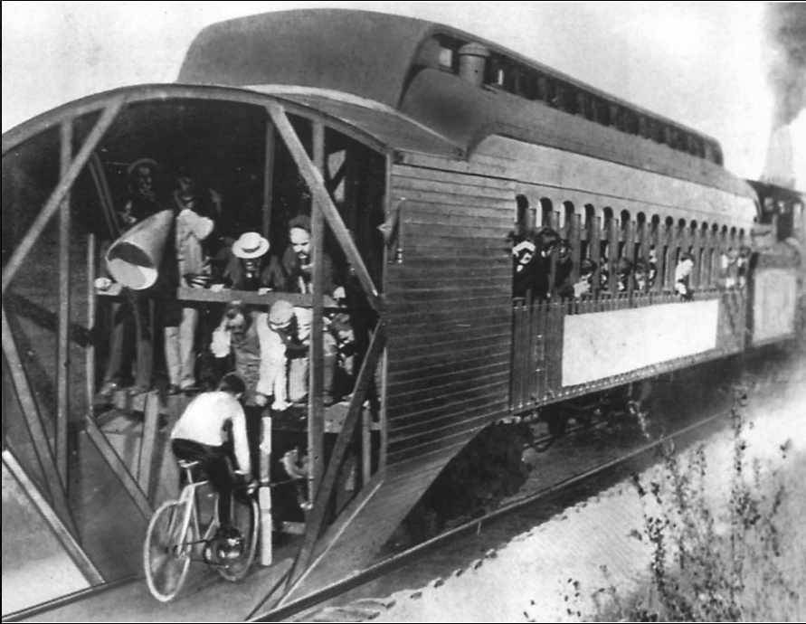 Charles M. 'mile-a-minute' Murphy on his bicycle riding behind a Long Island Railroad train. Time: 57 4/5 seconds over the mile span. Photograph, June 30, 1899.