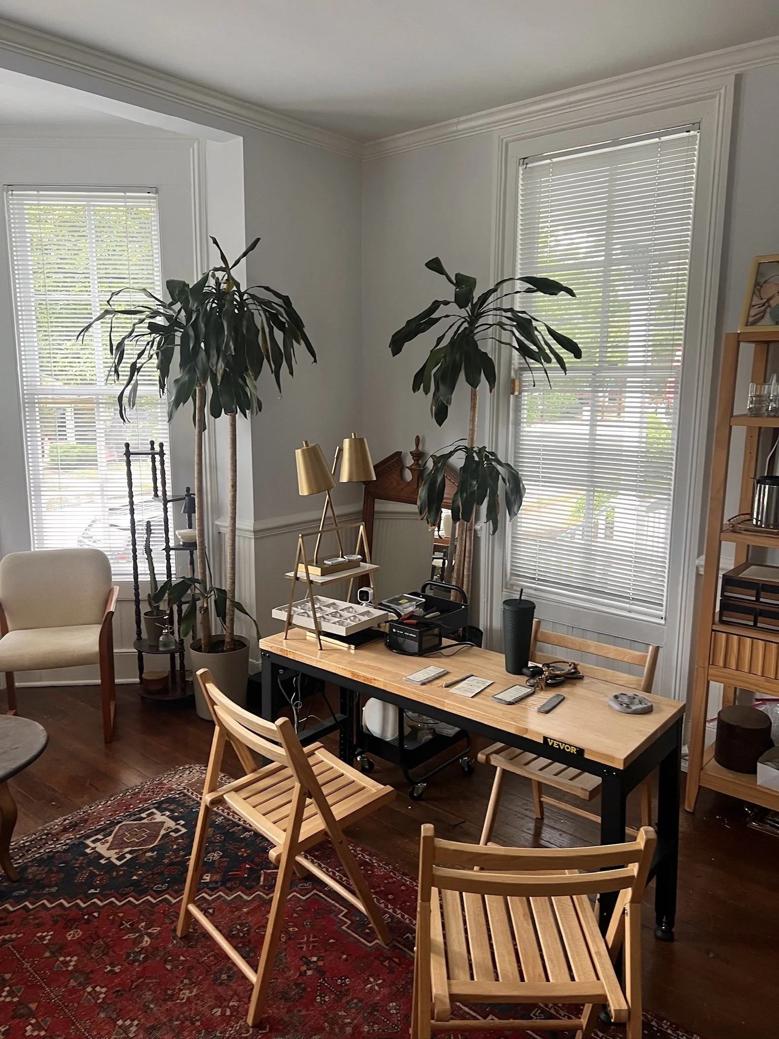 Interior view of the HEIR Raleigh jewelry welding station featuring a wooden table, chairs, and potted plants.
