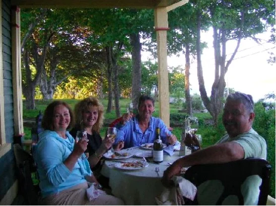 Lynn and George Butler, wearing blue, celebrate with guests on their front porch