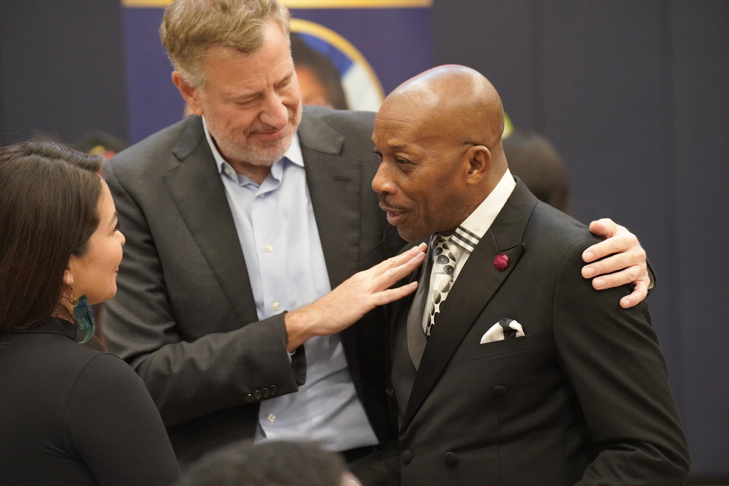 Four people engaged in a warm conversation at a formal event, smiling and making eye contact.