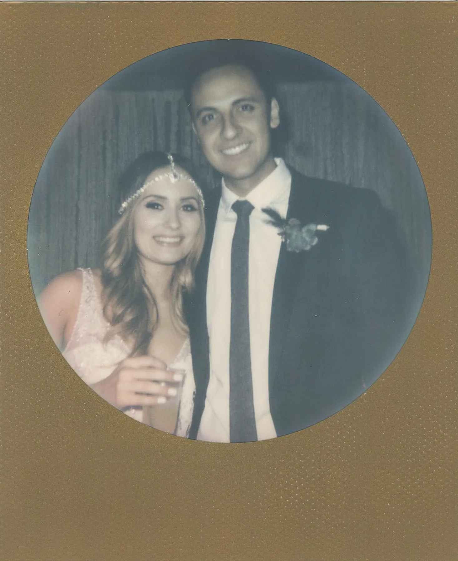 Bride and groom in gold round framed polaroid