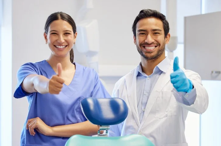 Portrait-of-two-young-dentists-showing-thumbs-up-in-their-consulting-room-1371010290_729x483.jpeg