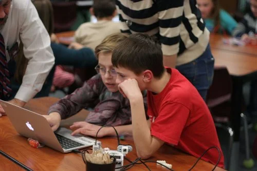 Two friends discussing the best way to get a robot to make decisions. Hard fun at its best!