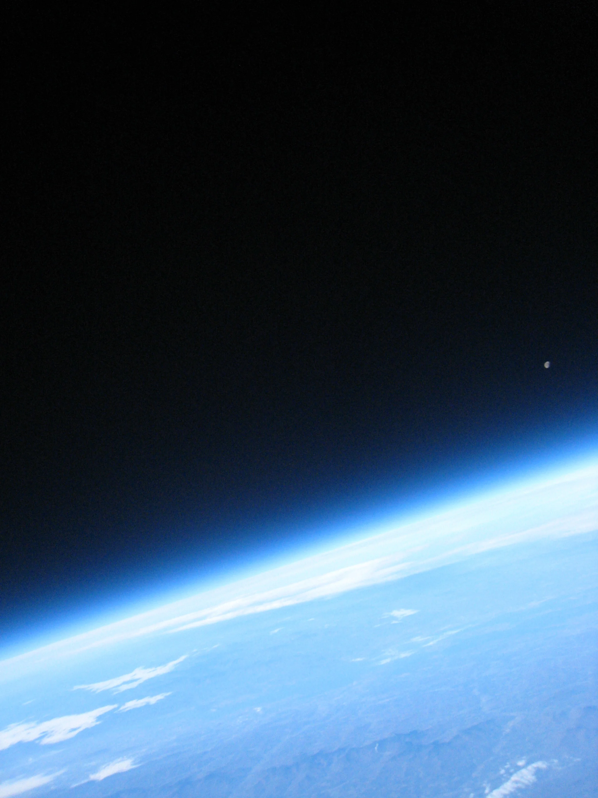 Picture from an altitude near 98,000 feet. Looking west at the setting moon. Vermont's Green Mountains are visible. Profile's payload box made it to "near space" and we had the pictures to show for it! 