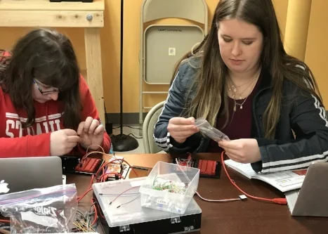 Two hack-and-hangers get ready to program their first Redboard circuits.