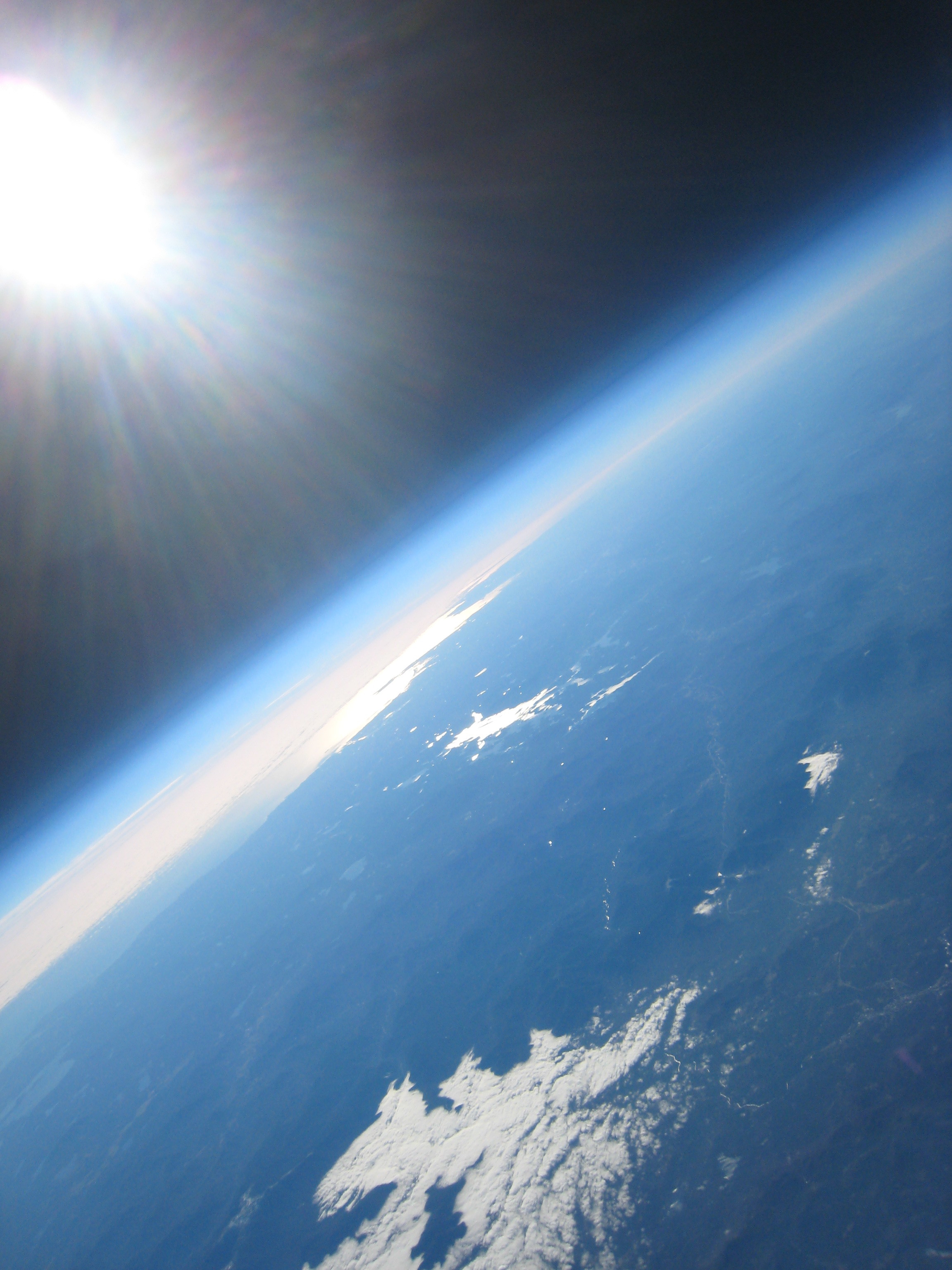 Looking south from near our high point over the Vermont, New Hampshire border. In this image you can see the town of Littleton (lower right), the snaking line of interstate 93 moving through Franconia Notch, the alpine zone of Mt. Washington (left of clouds), the bright shape of lake Winnipesaukee, the Atlantic Ocean, and Cape Ann off the Massachusetts coast. Hidden in a cloud bank is Cape Cod!