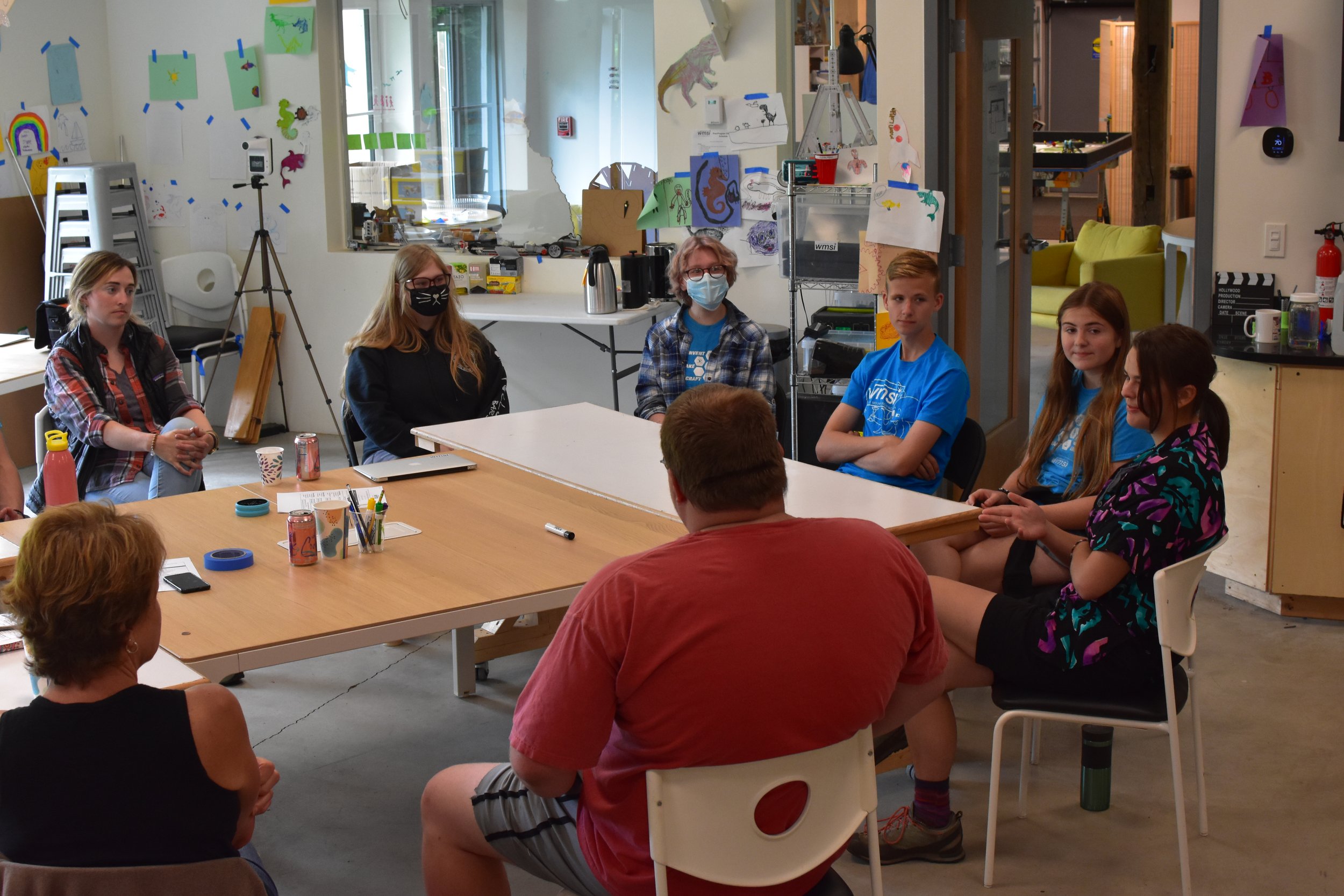  WMSI Staff, Blue Shirts and partner teachers sit in a discussion circle 