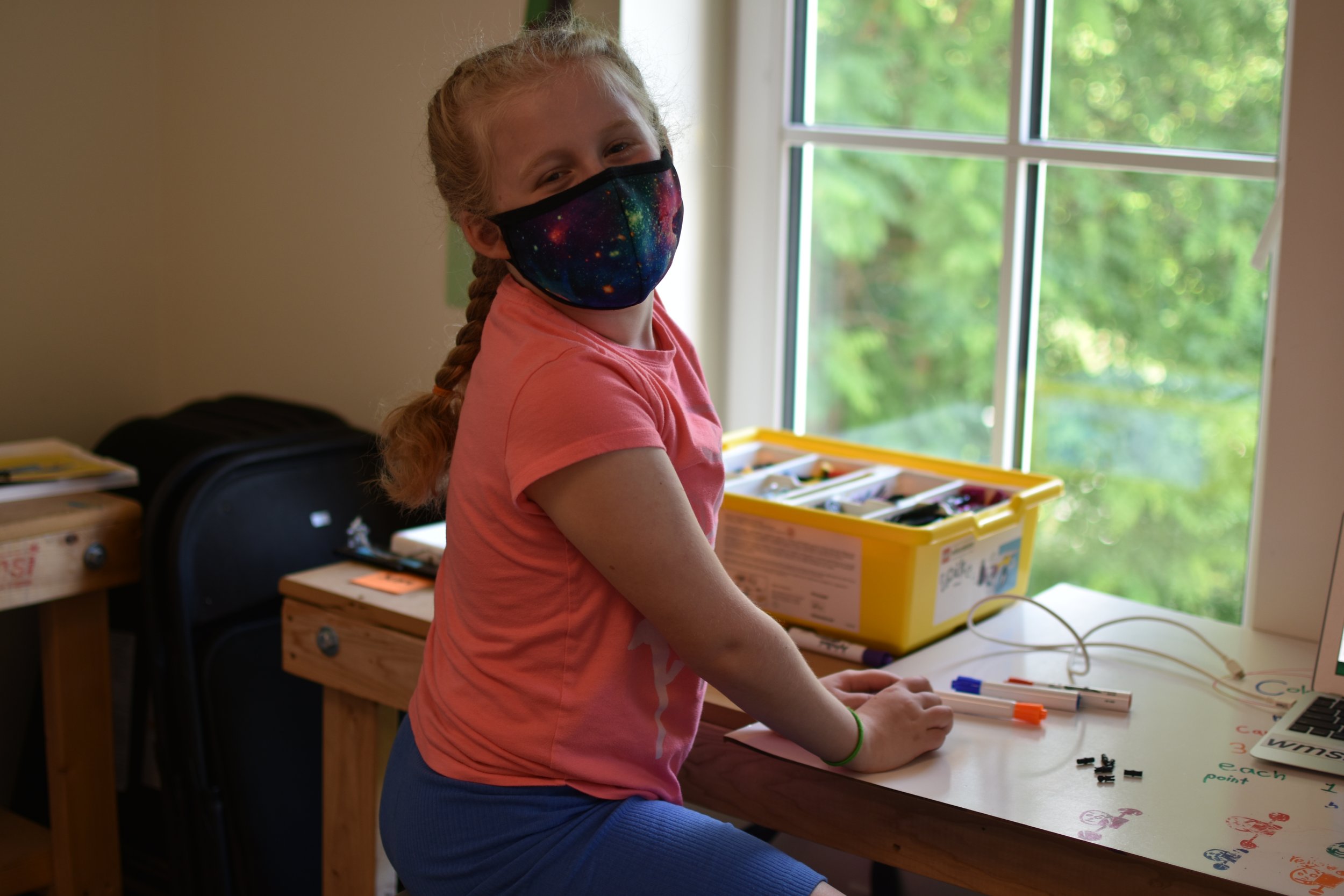  A WMSI student smiles over her shoulder while working on LEGO SPIKE Prime 