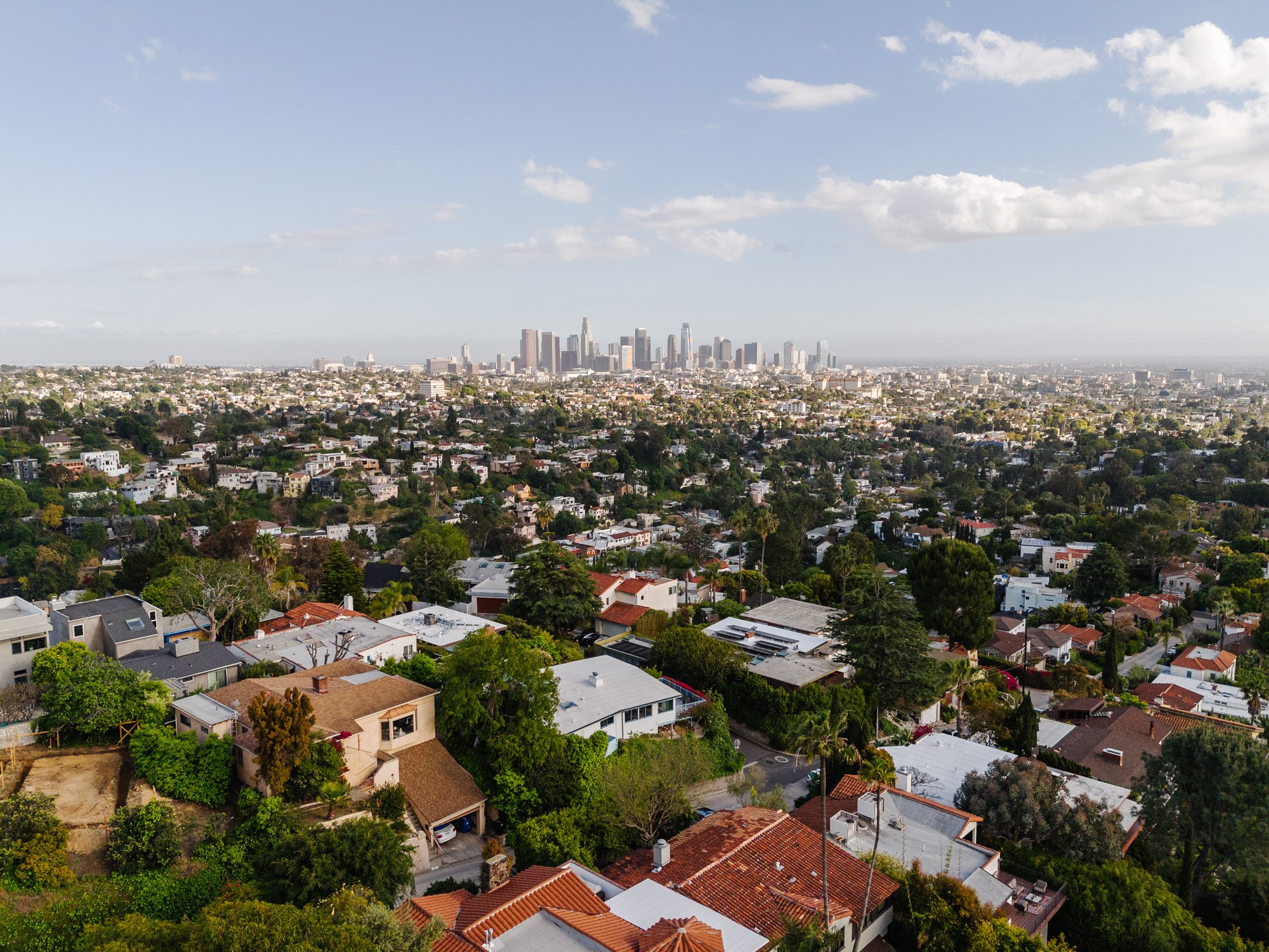 Aerial view of Silver Lake hillside homes with Downtown Los Angeles skyline in the background