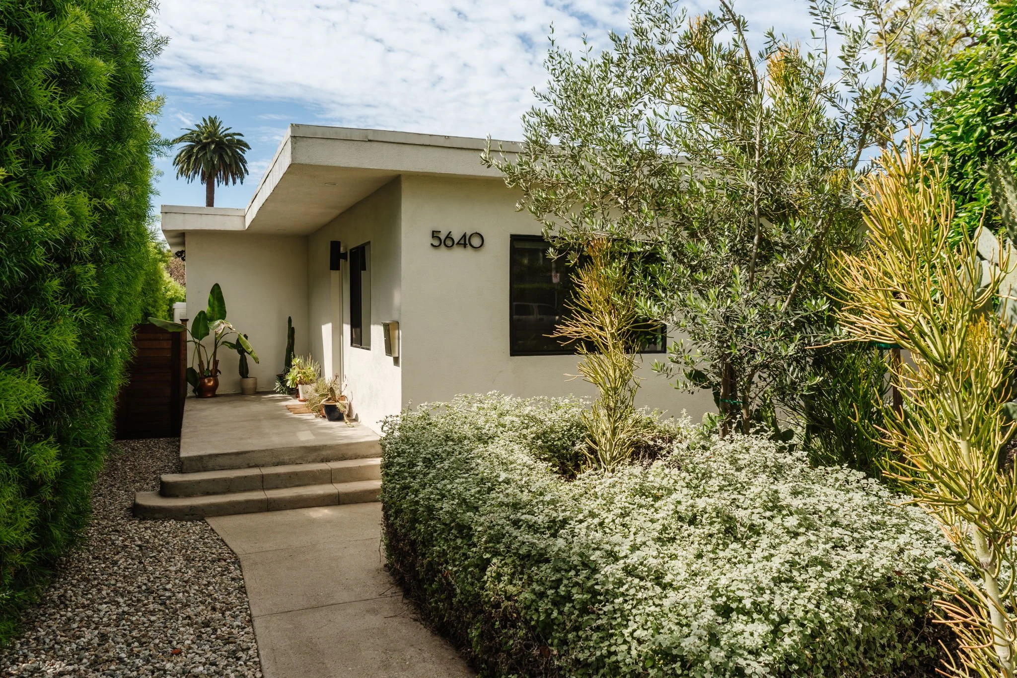 Highland Park home for sale at 5640 Irvington Pl in Los Angeles with modern exterior, landscaping, and private entry walkway