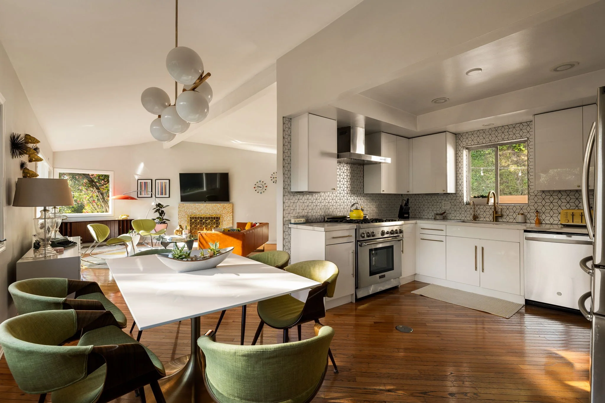 Open concept living dining and kitchen space with mid-century design and natural light in Glendale home