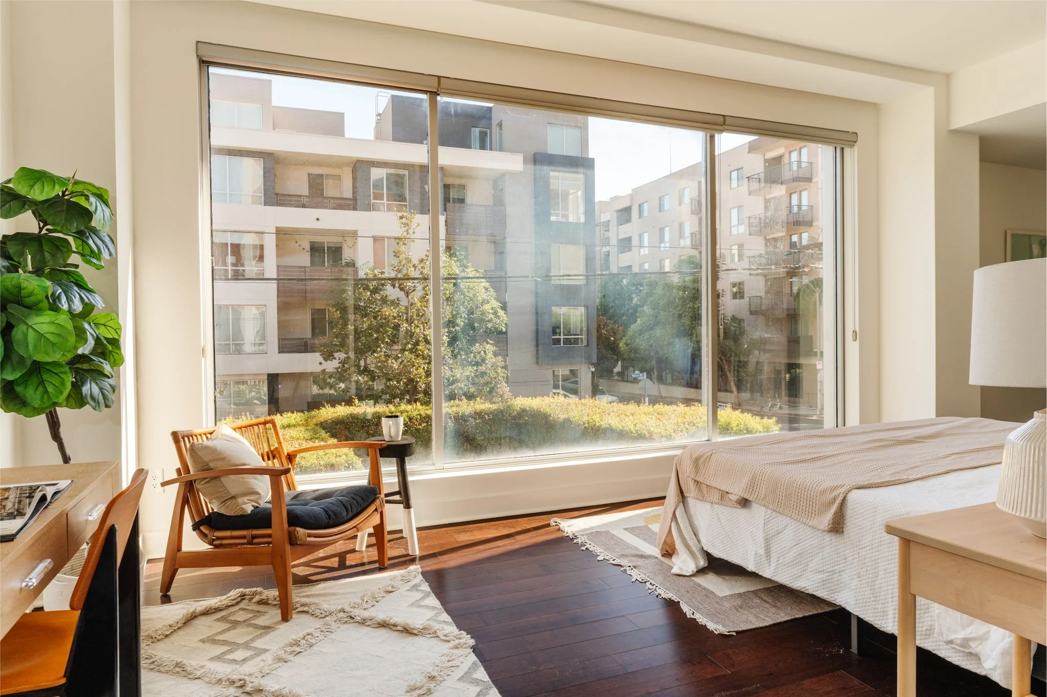 Light-filled primary suite with hardwood floors and expansive windows at 6735 Yucca St, Unit 209