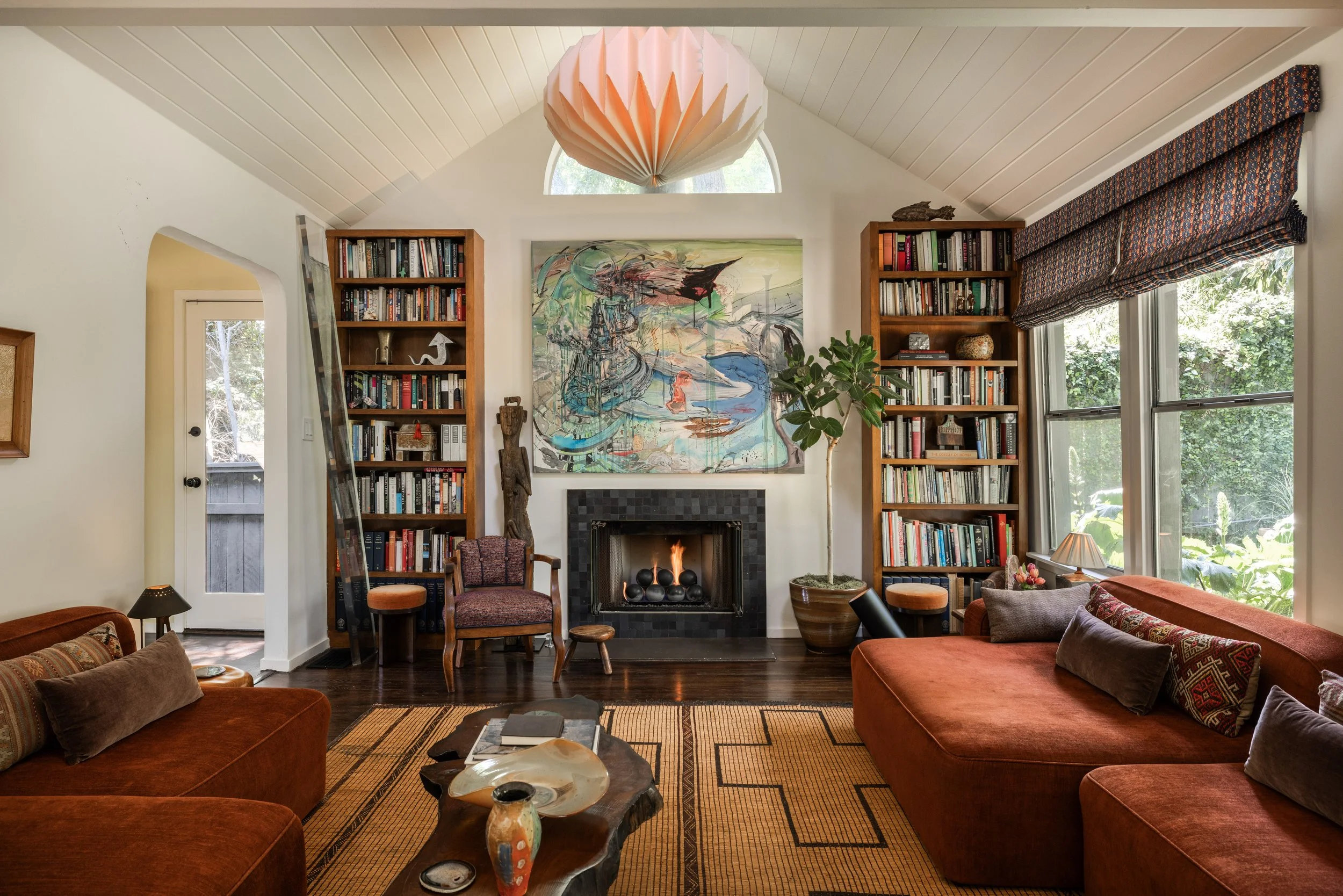Living room at 1452 Westerly Ter in Silver Lake with vaulted ceiling, built-in bookshelves, working fireplace, and abundant natural light.