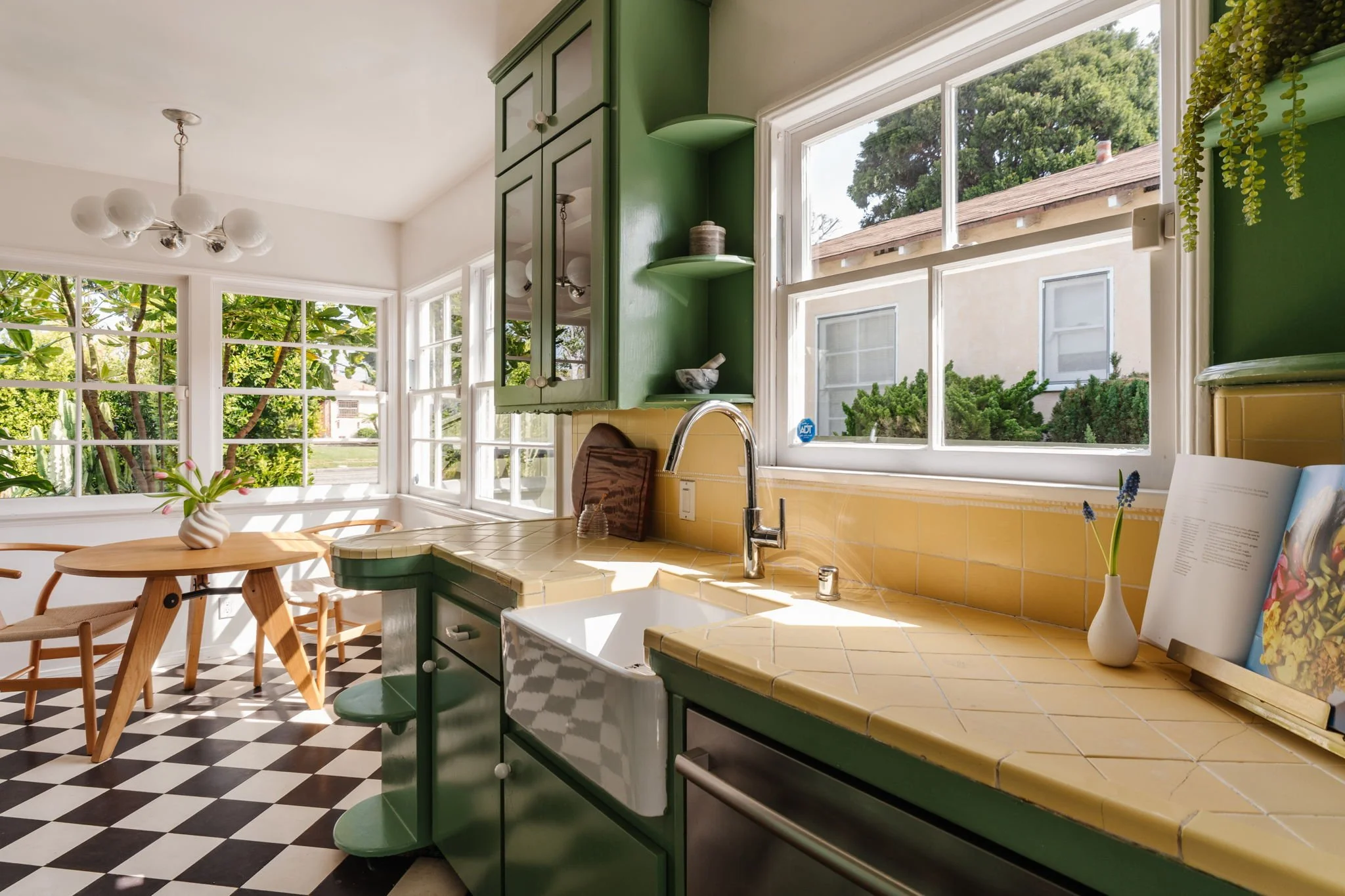1950s kitchen with original yellow tile countertops and green cabinetry in Los Angeles