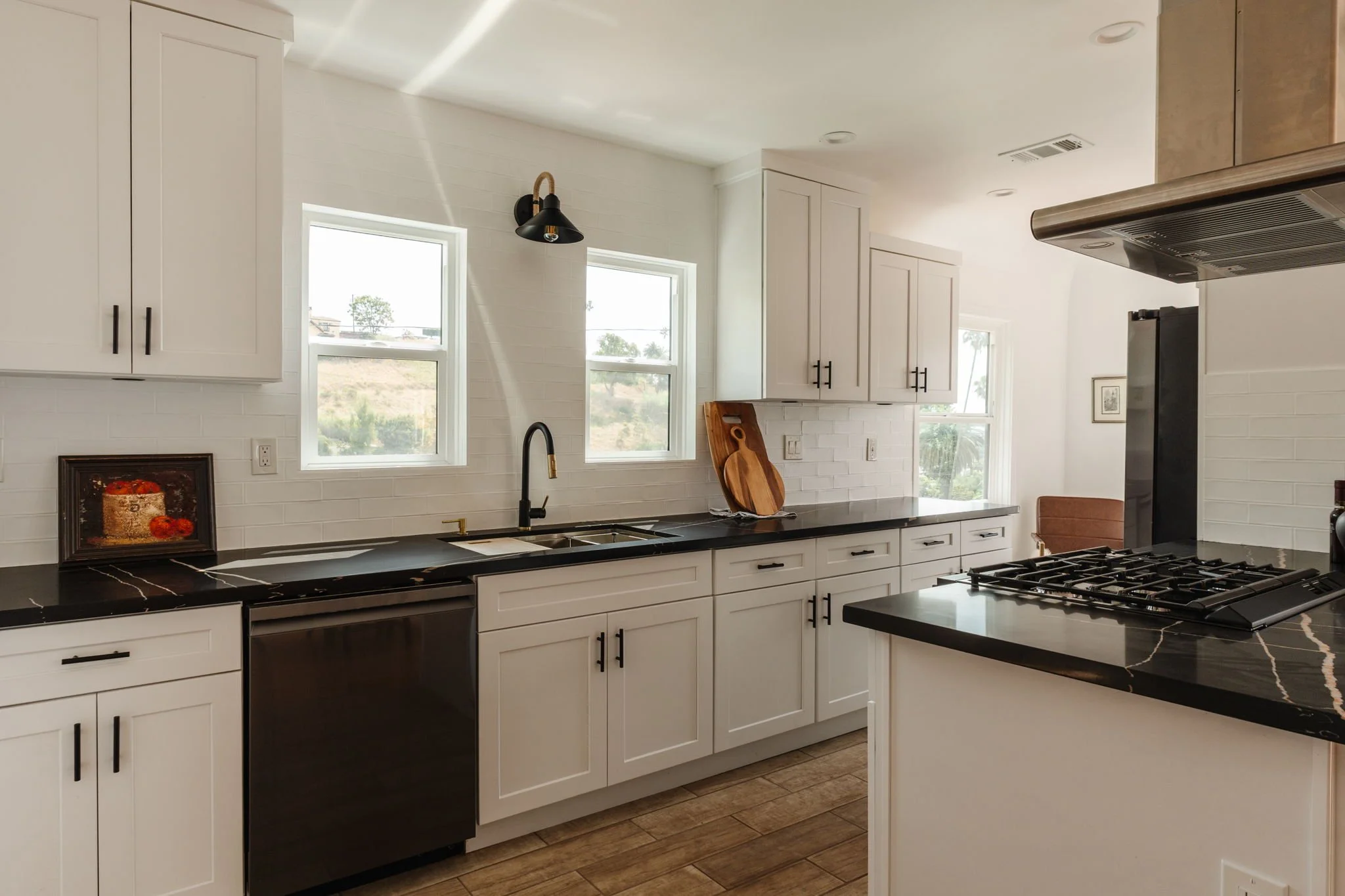 Updated kitchen with black countertops in renovated Spanish-style Los Angeles home