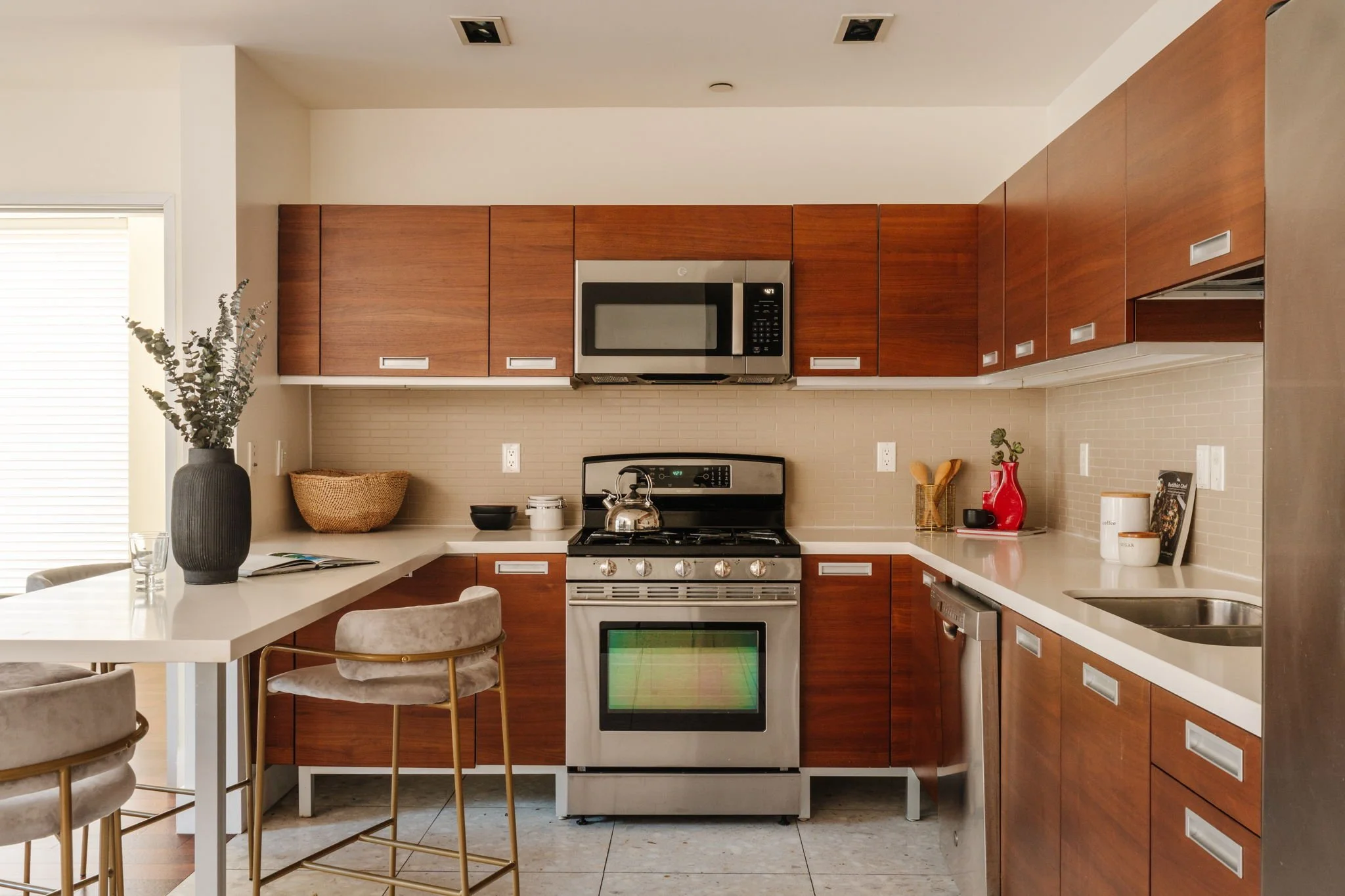 Kitchen with wood cabinetry, stainless steel appliances, and breakfast bar at 6735 Yucca St, Unit 209