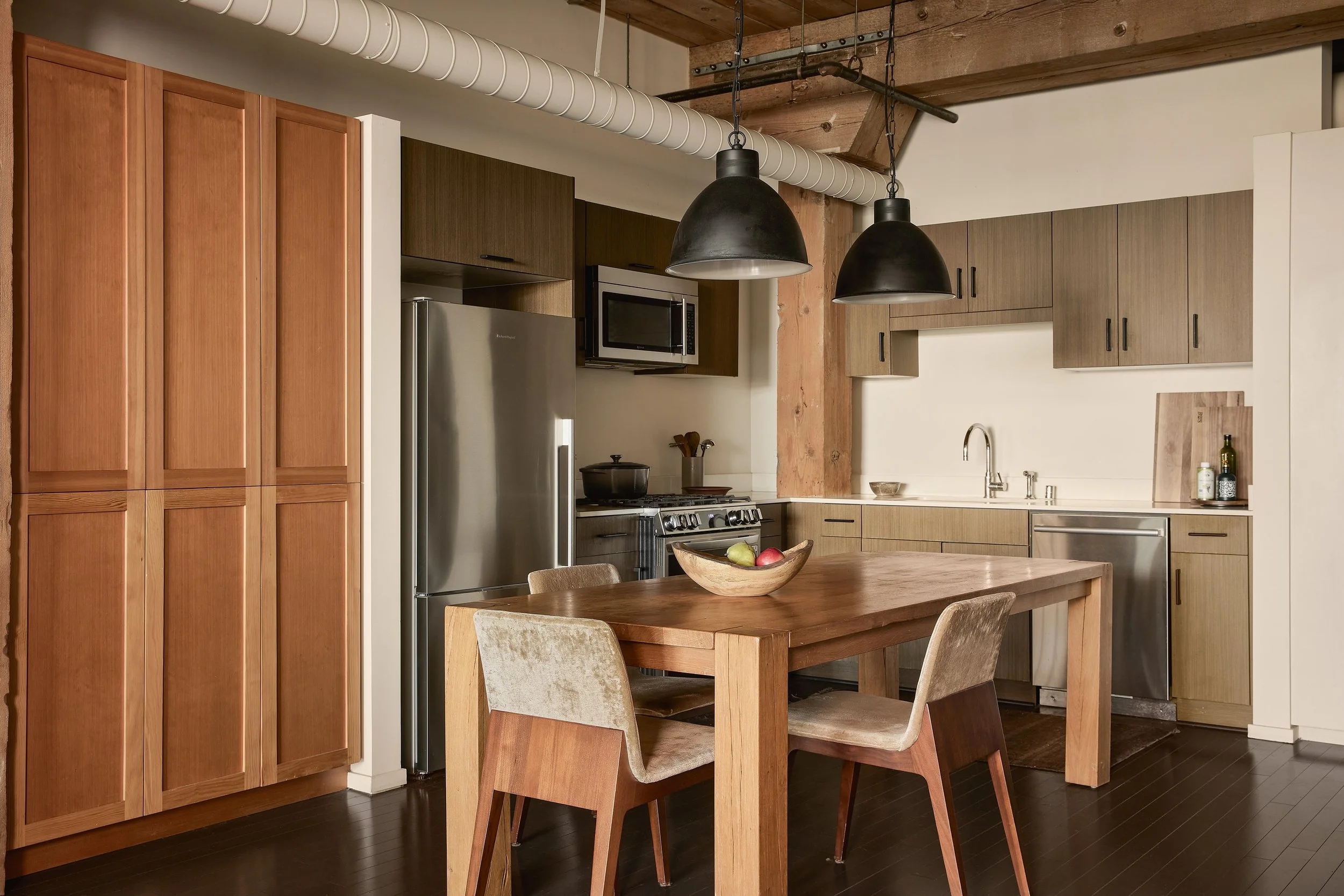 Updated chef’s kitchen at Barker Block featuring premium appliances, modern cabinetry, and a spacious dining setup within a bright, open loft layout.