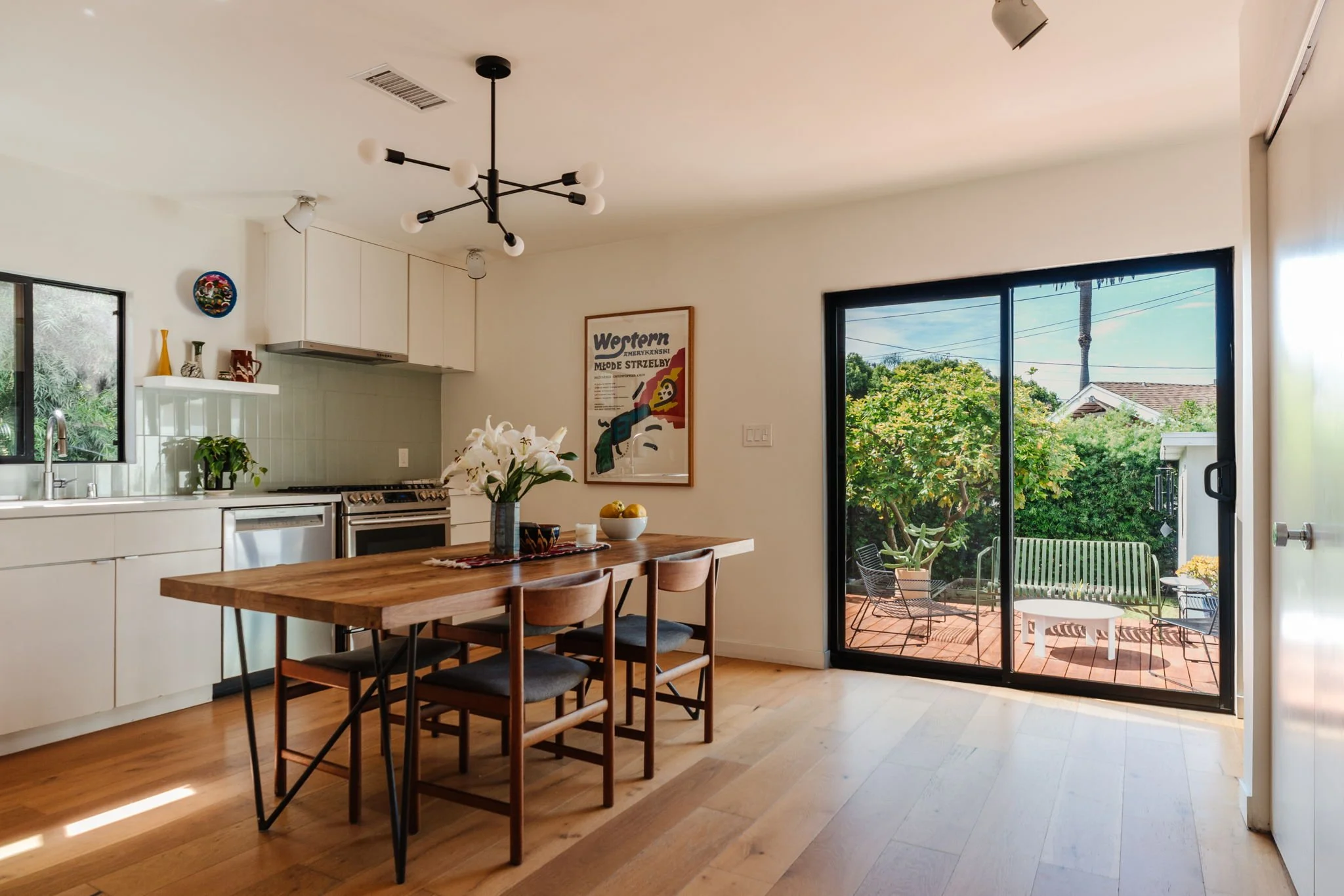 Open kitchen and dining area in Highland Park home for sale with sliding doors leading to outdoor deck