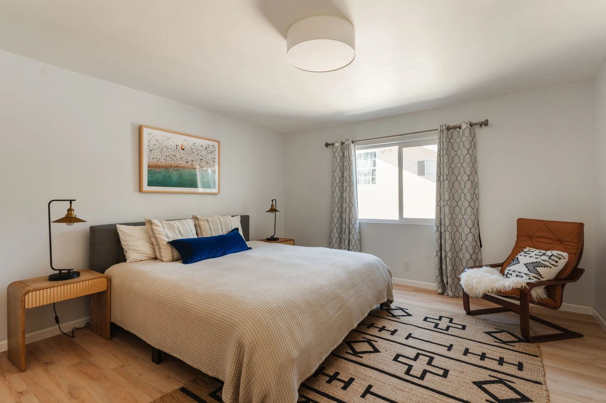 Bedroom with light-toned flooring, a large window, and space for a reading chair at 1559 Winona Blvd, Unit F2.