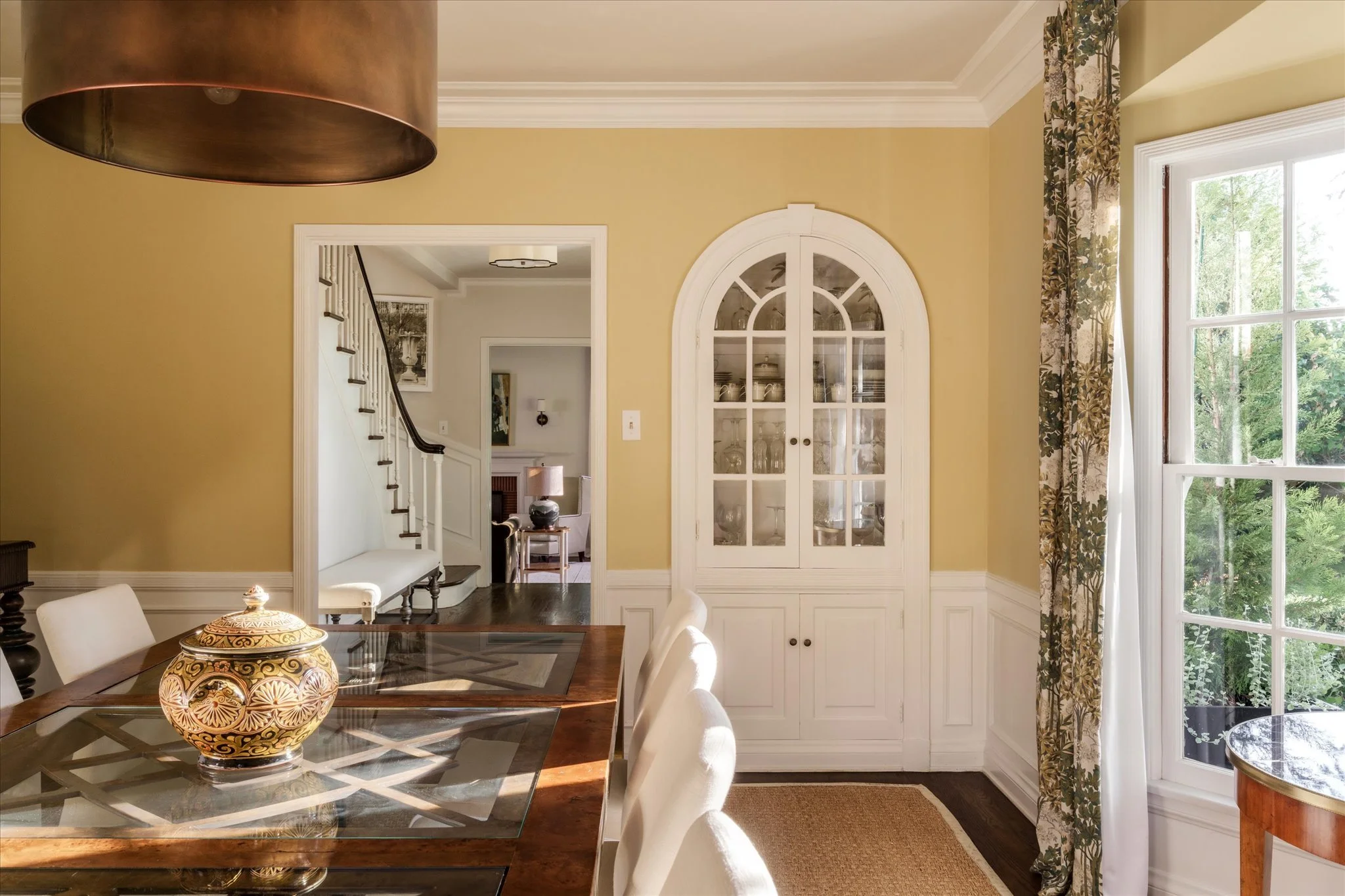 Formal dining room with original arched built-in cabinetry, hardwood floors and period details at the Glendale Colonial Revival home.