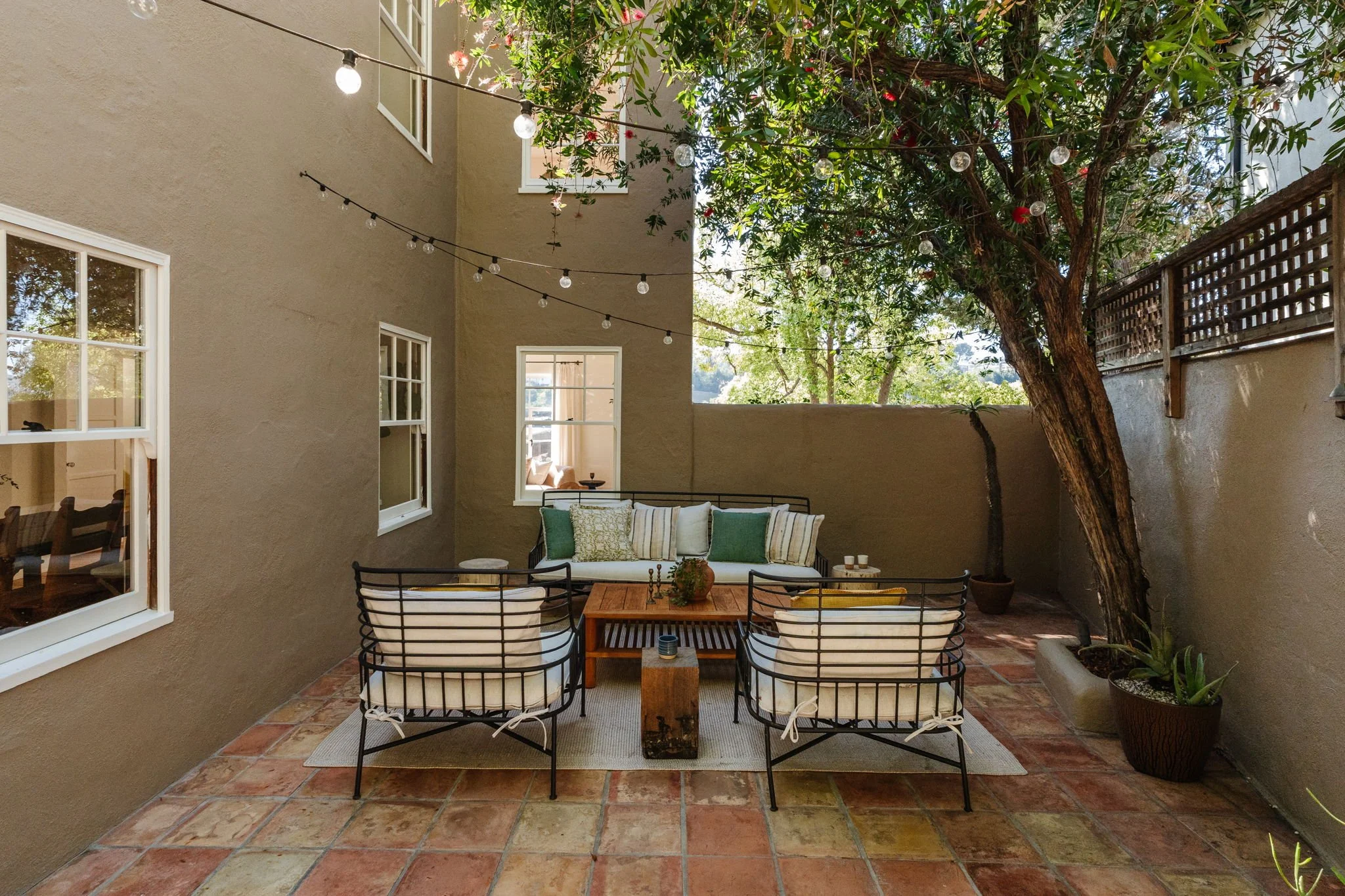 Private outdoor patio with seating and mature trees at Silver Lake Spanish home