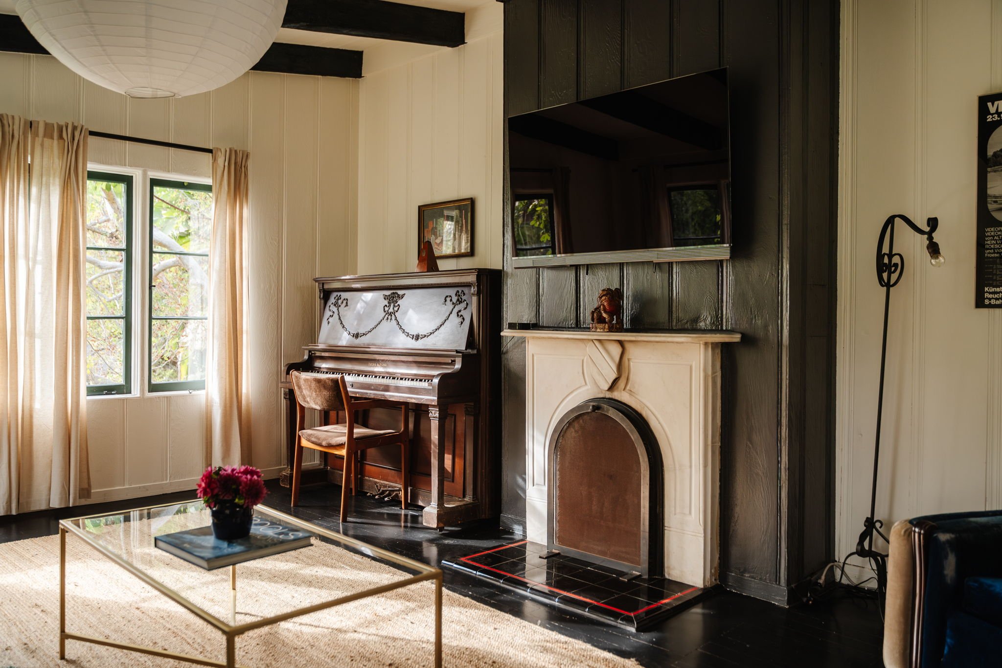 Living room with original fireplace and piano in a historic Whitley Heights Spanish home