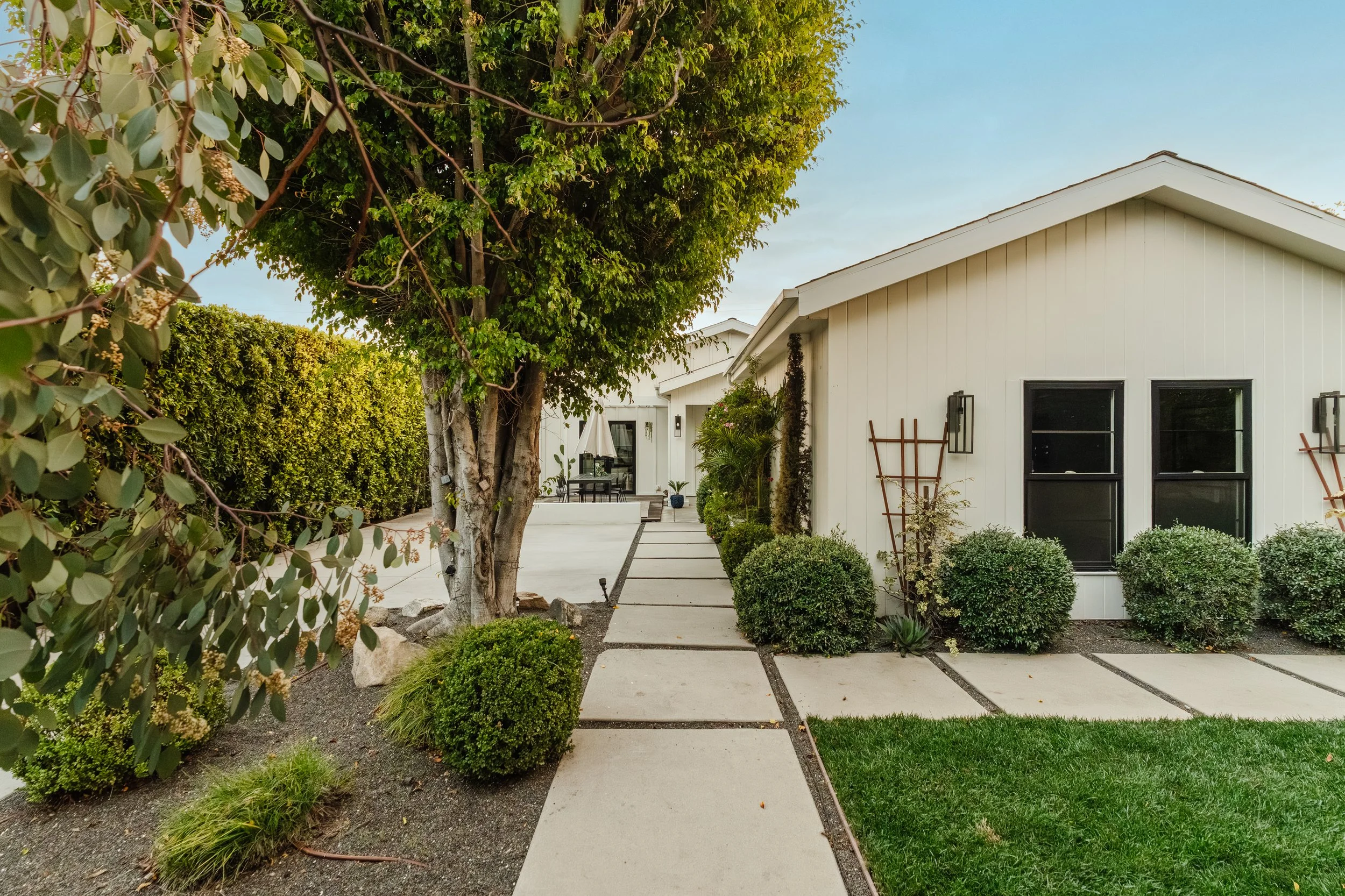 Front exterior of Modern Farmhouse by Allprace at 4128 Baywood St in Atwater Village, featuring oversized lot, mature landscaping, and private walkway.