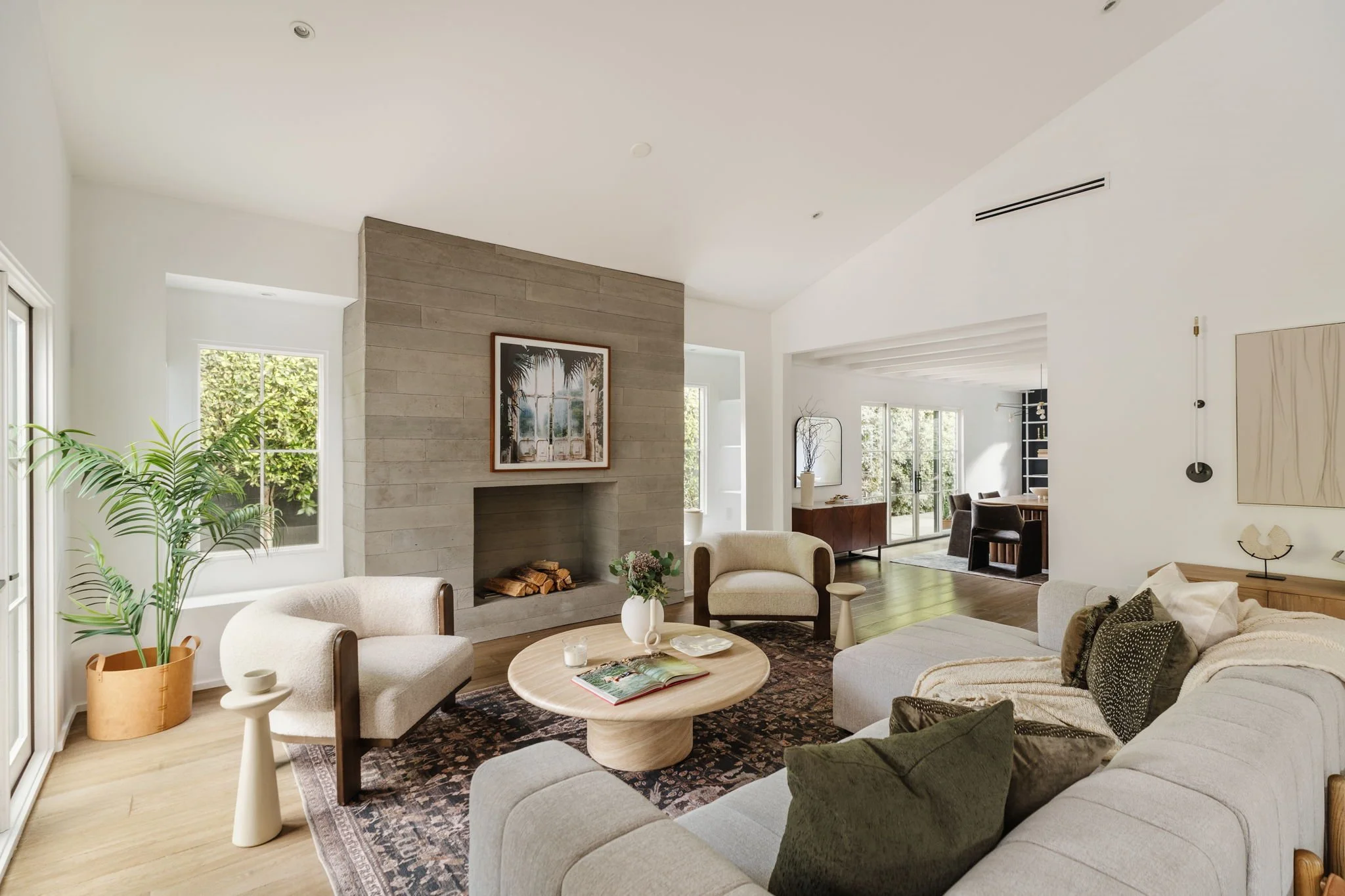 Light-filled great room at 4128 Baywood St in Atwater Village with board-form concrete fireplace, wide-plank floors, and seamless indoor-outdoor flow.