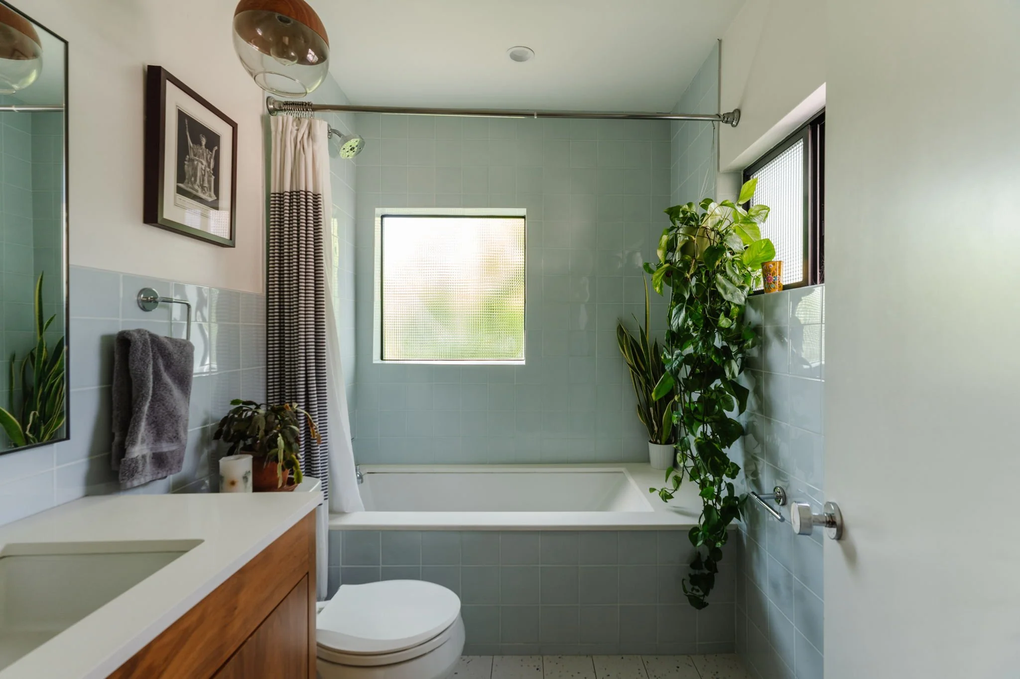 Updated bathroom in Highland Park real estate listing with green tile, soaking tub, and modern finishes