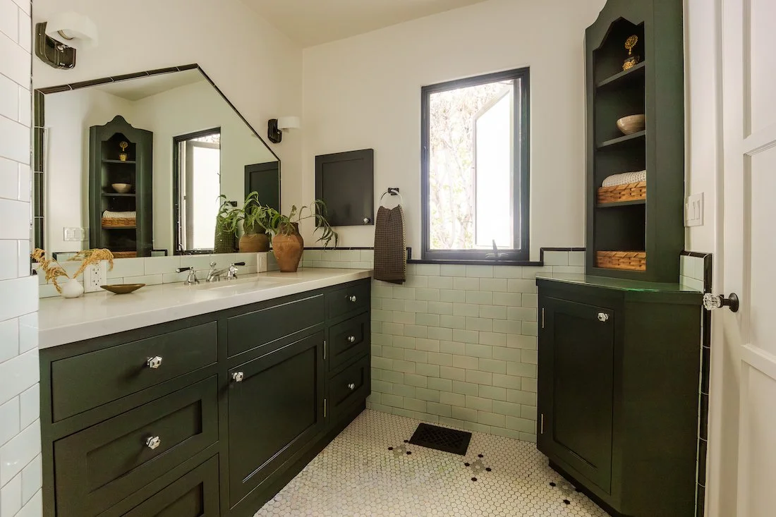 Renovated bathroom with custom cabinetry, vintage-inspired tilework, hex tile floors, and a large vanity blending classic Spanish style with modern updates.