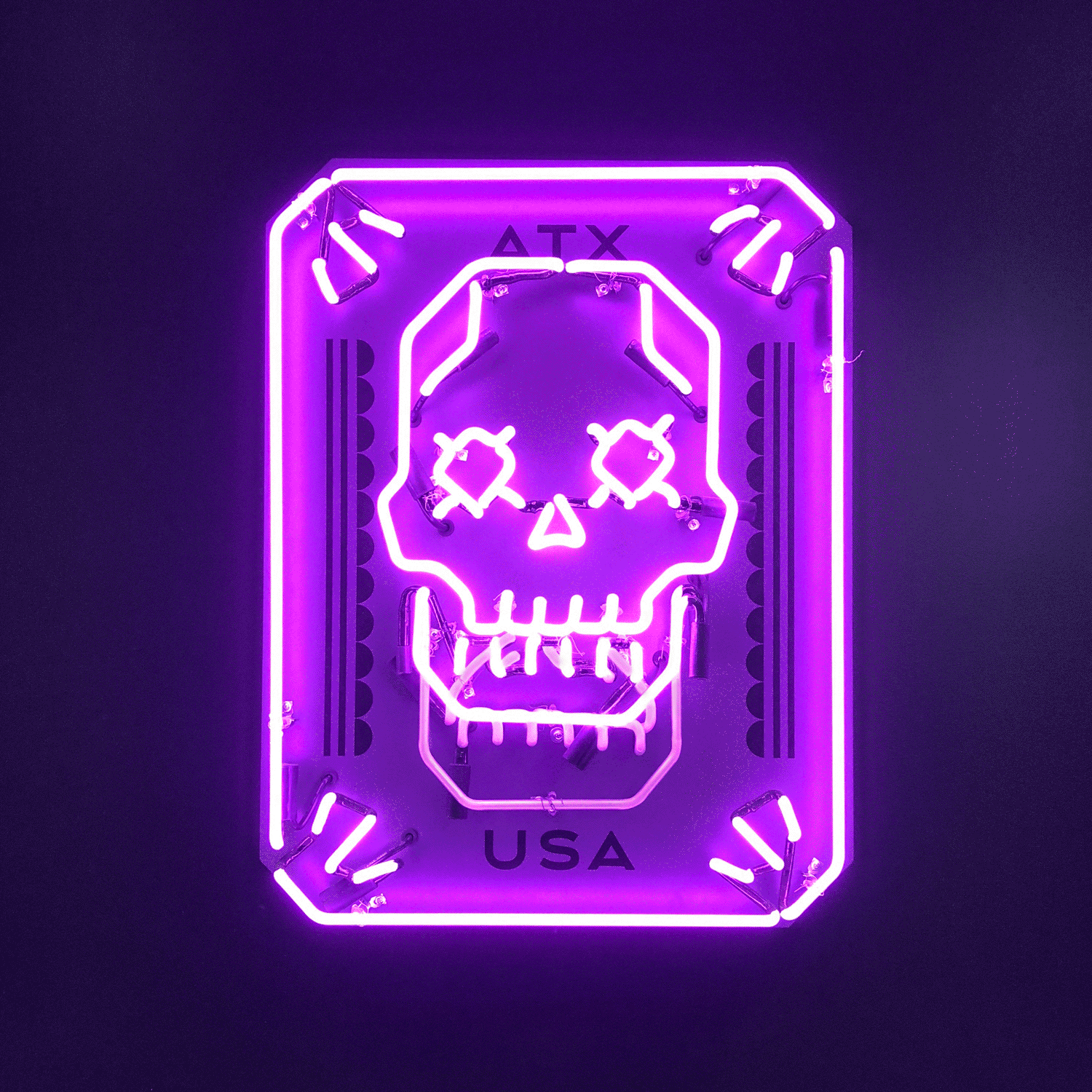Pink neon sign of a stylized skull with "ATX" and "USA" text.