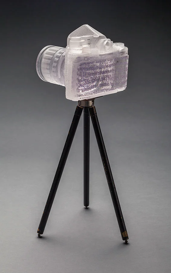   Ptolemy's Pentax  (back view); 2014; 7 x 7.5 x 6 inches; cast glass, ceramic decal, paint, antique Kodak tripod 