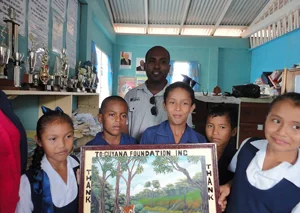 Students of Santa Rosa Primary donate a painting to Managing Director of The Guyana Foundation, Anthony Autar, after the school was given a $2M donation to upgrade its facilities.