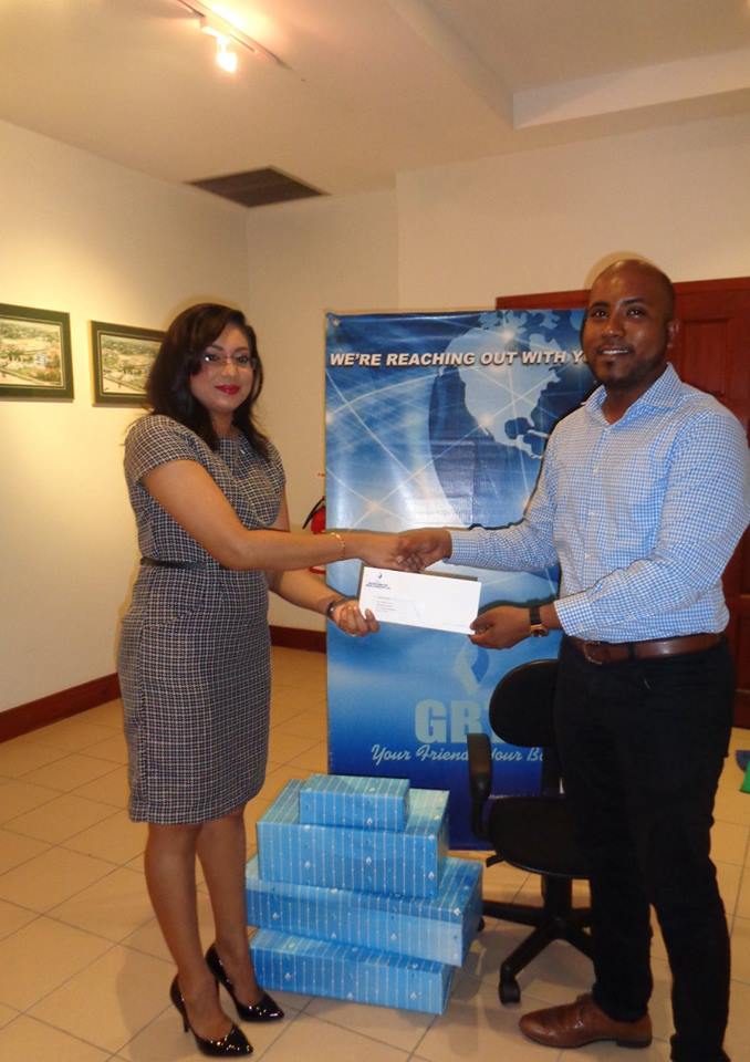 Managing Director of Guyana Foundation, Anthony Autar, receiving the donated items from Ms. Pamela Binda, Public Relations and Marketing Manager at GBTI