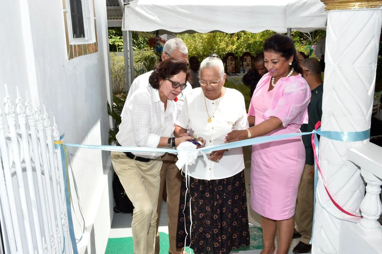 First Lady, Mrs. Sandra Granger and Mrs. Supriya Singh-Bodden help Mrs. Seraji Sankar to cut the ribbon to officially open the Guyana Foundation Sunrise Centre at Zorg-En-Vlygt, Essequibo Coast.