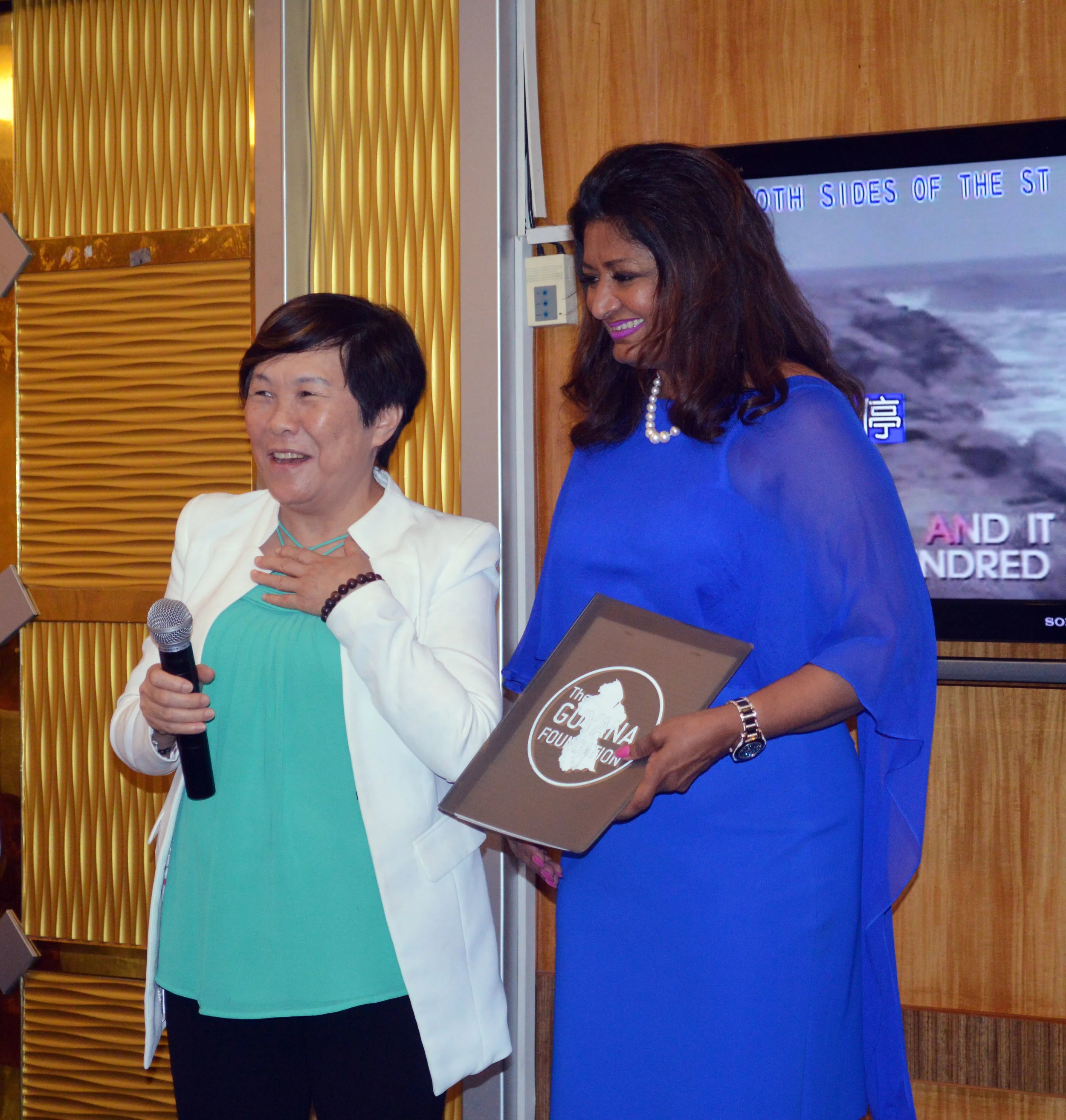 Mrs. Che Jian Ping gaving brief remarks after officially joining the Board of Trustees of the Guyana Foundation. Standing next to her is the Founder of the Guyana Foundation, Mrs. Supriya Singh-Bodden.