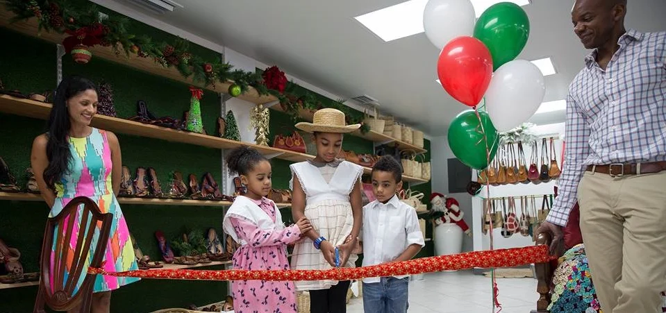 Chloe, Naomi and Asher with their Mom, Joannah and Dad, Peter, cut the ribbon dressed in old style Caymanian costumes.