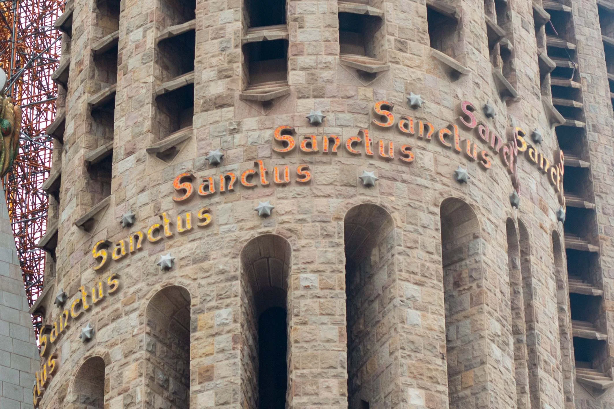 SANCTUS, LATIN FOR HOLY, INSCRIBED AROUND THE TOWERS ON THE PASSION FACADE