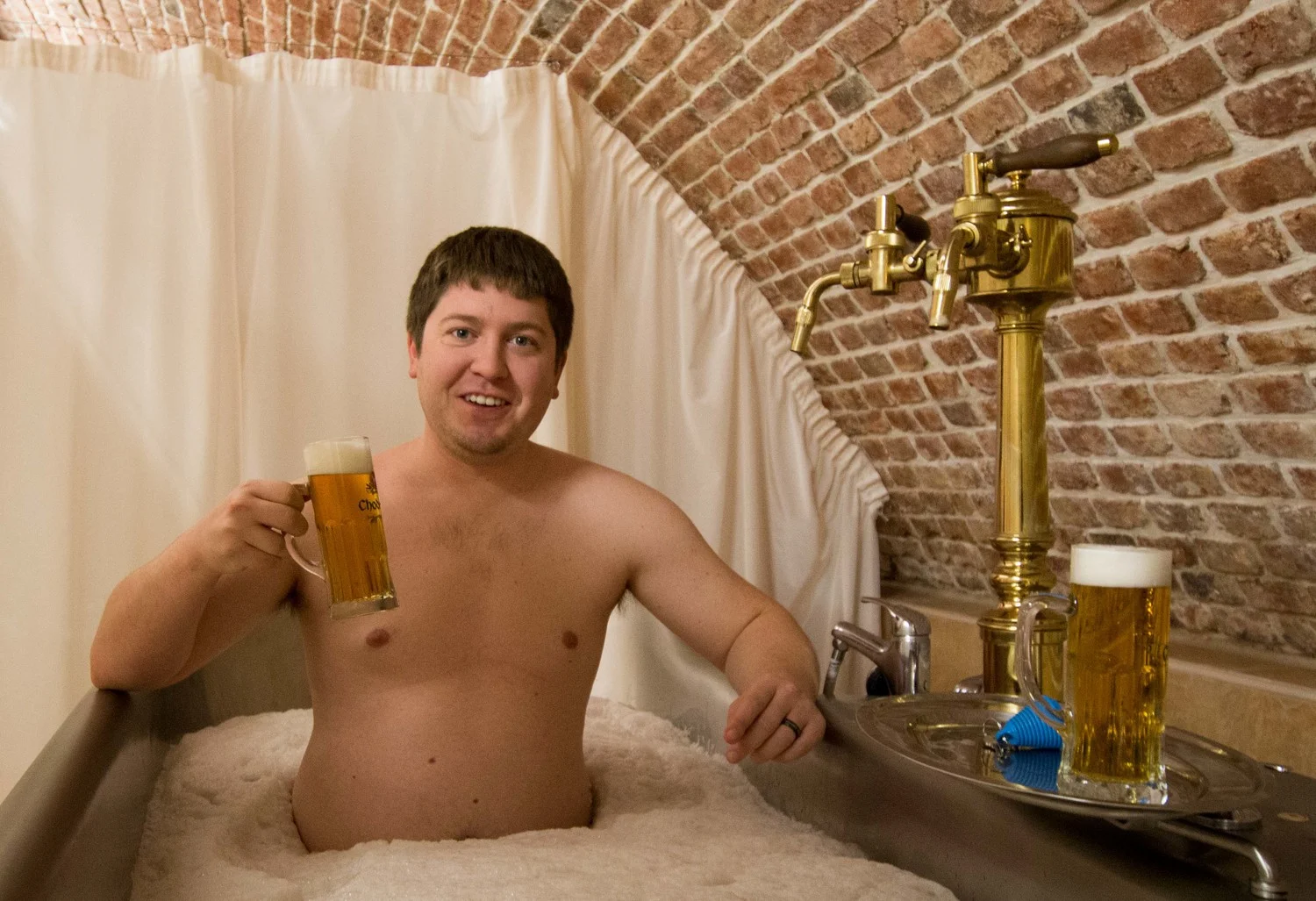 aaron drinking a beer while bathing in beer