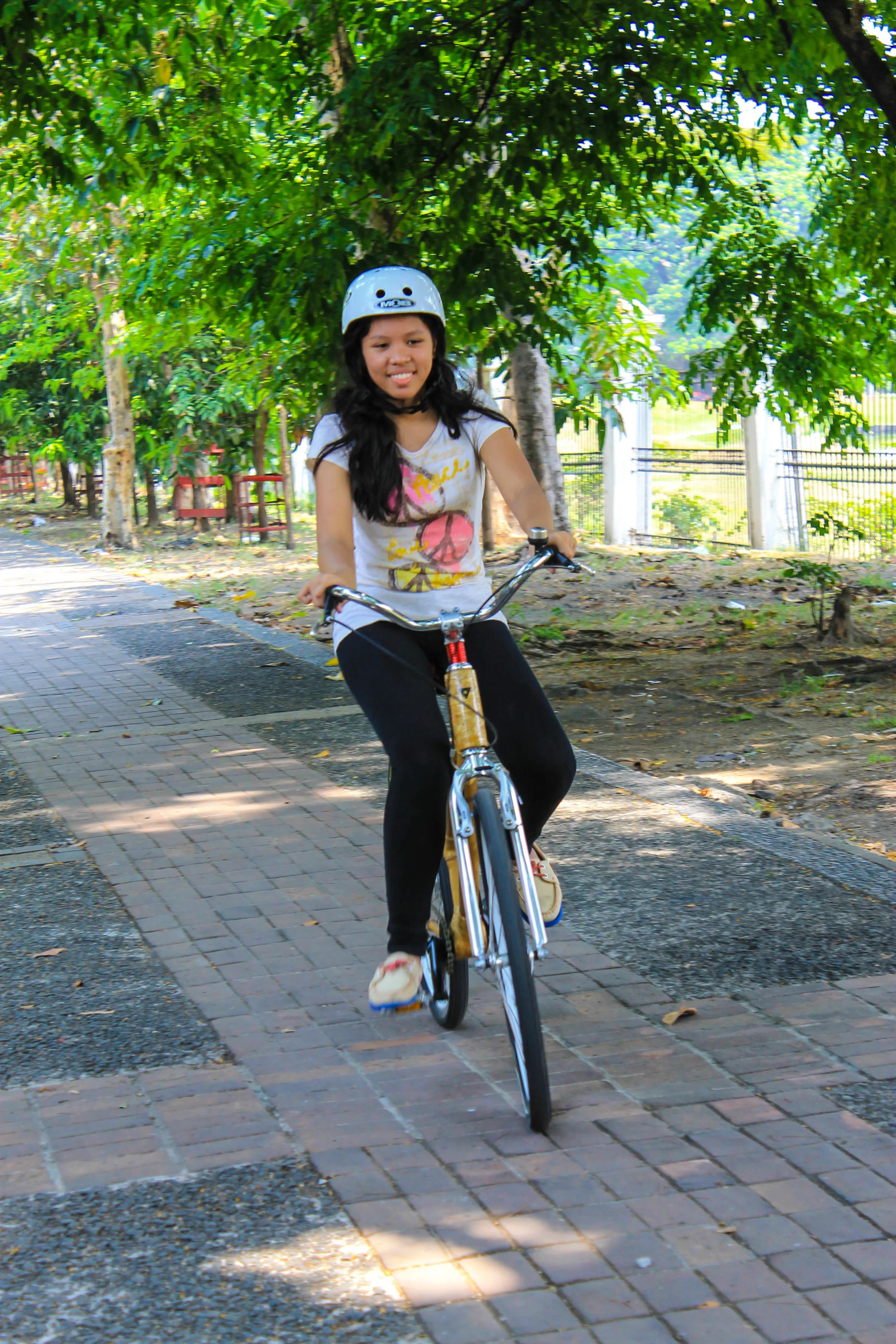 Bambike Intern Linet Dumag riding a company bicycles in the park.
